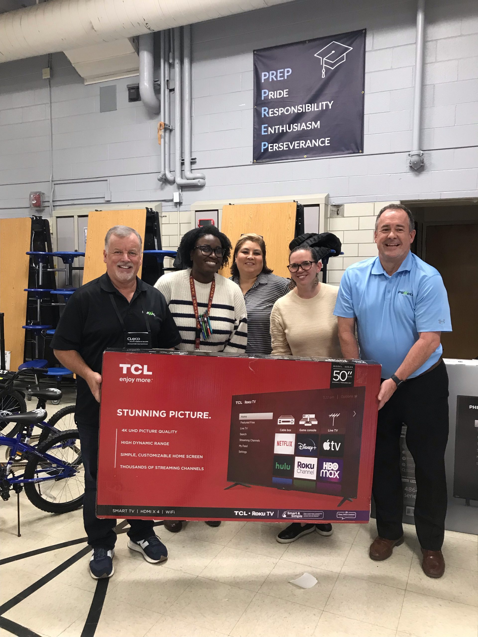 Bobby Brown (Left) and Craig Hansen (Right) of PMWeb donate a 50-inch Smart TV to University Prep in Denver, CO.